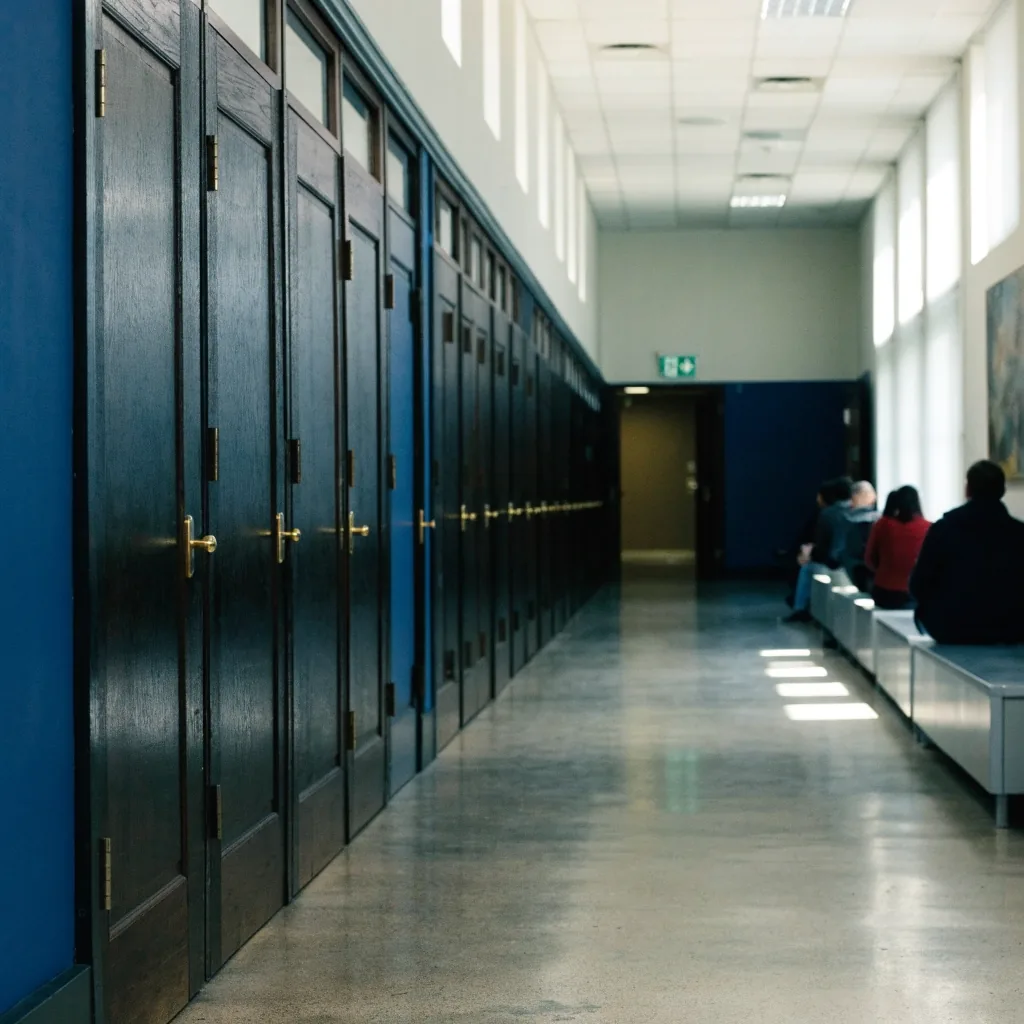 A quiet hallway outside a United States immigration courtroom with people waiting at a distance